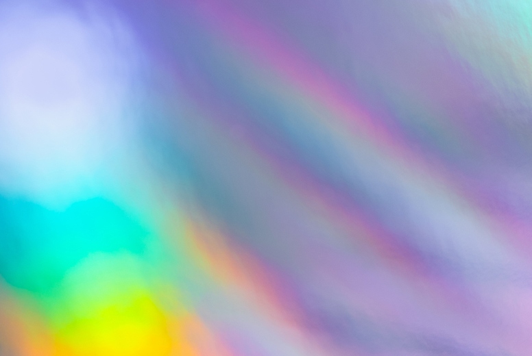 Soft colorful abstract background with blurred light reflections in purple, blue, and pink tones, creating a dreamy gradient texture.