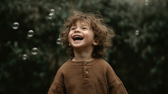 Joyful child laughing while playing with bubbles in natural outdoor setting  capturing essence of childhood happiness