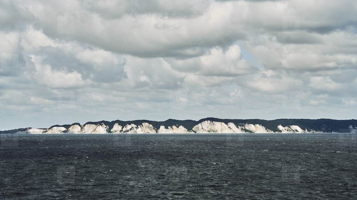 Scenic view of white cliffs of Denmarks coastline under fluffy