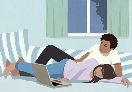 Couple watching movie on laptop on bed at night