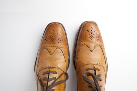 Tan brogue shoes on background