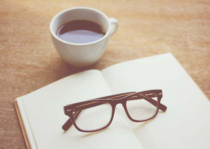 Eyeglasses on notebook and black