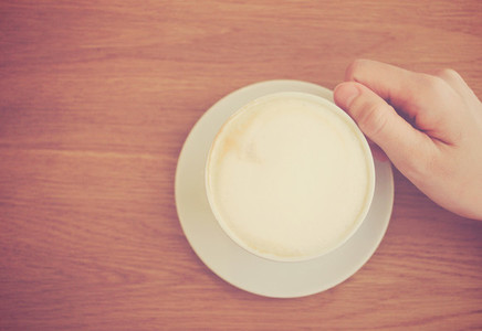 Hand holding cup of latte