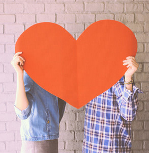 Couple holding paper heart