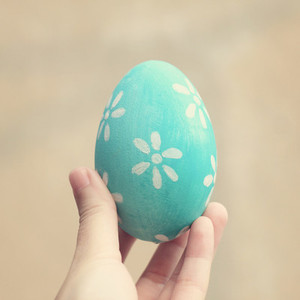 Hand holding painted easter egg