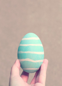 Hand holding painted easter egg