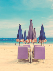 Beach chair and umbrella on sand