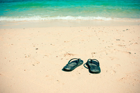 Flip flops on a sand ocean beach