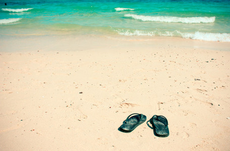 Flip flops on a sand ocean beach
