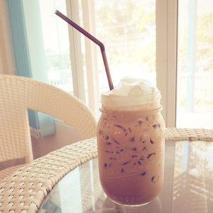 Iced coffee and straw on table