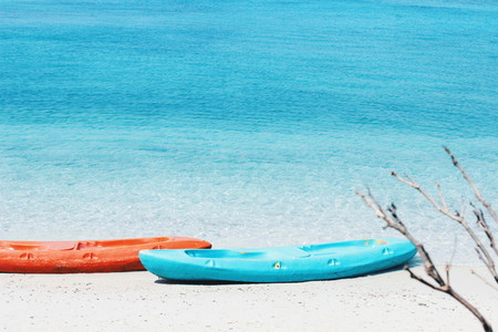 Orange and blue kayaks on sandy