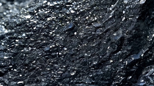 Textured black rock Obsidian surface with shiny