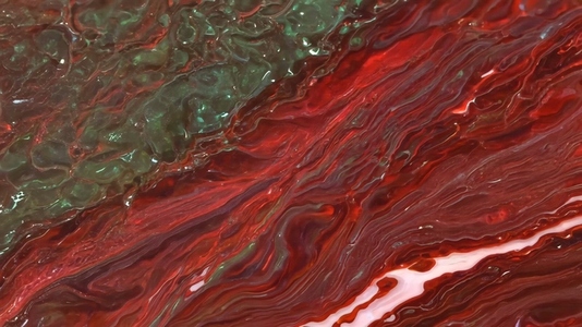 Close up of a textured surface with red and green hues