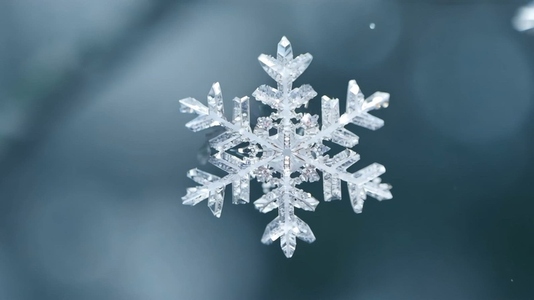 A close up view of a delicate snowflake with intricate patterns