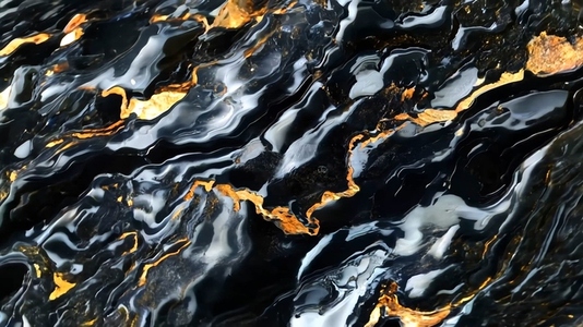 A close up view of dark  swirling water with golden reflections