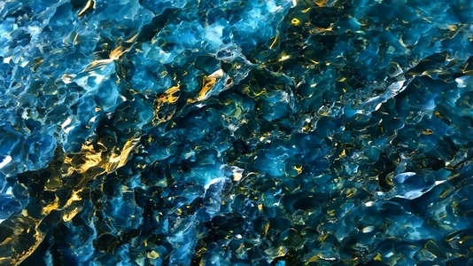 A close up view of shimmering water with vibrant blue and gold