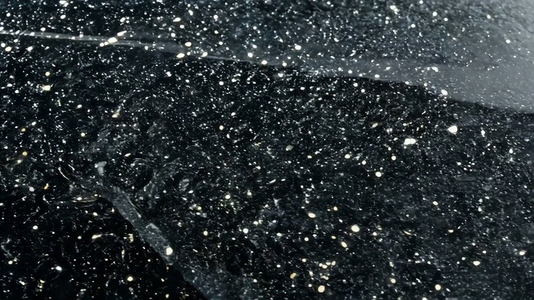 Close up of water droplets on a dark surface creating a texture