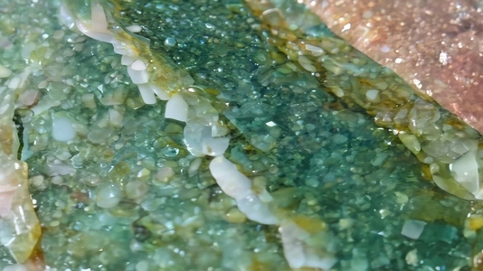 Close up of a textured Unakite surface with green and brown hues