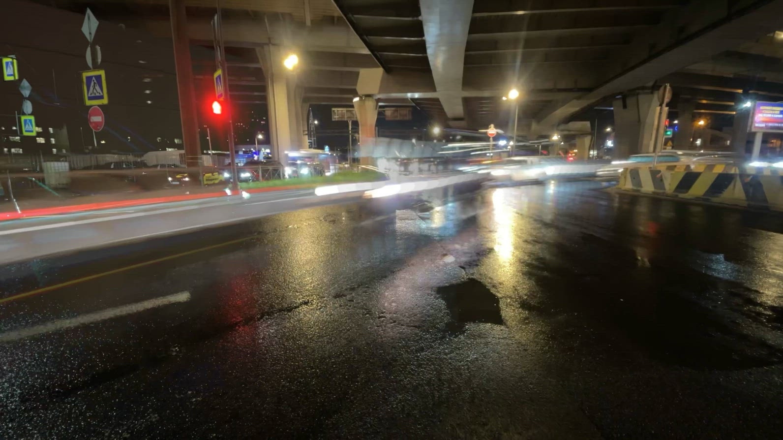 Nighttime timelapse urban scene with light trails under a highwa