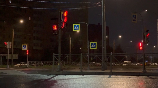 Nighttime urban street scene with traffic lights and pedestrian