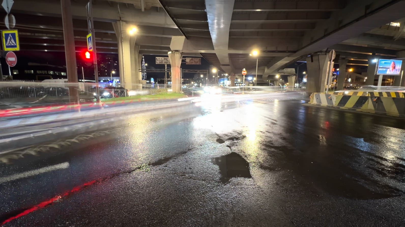 Nighttime timelapse urban scene under highway overpass with wet