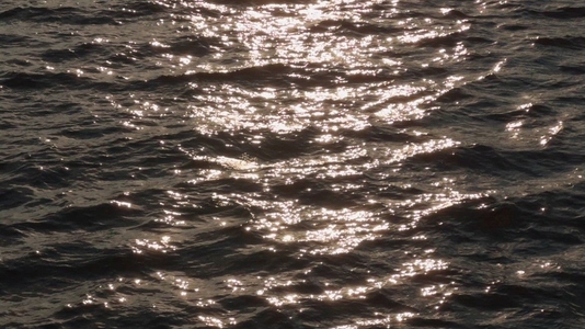 Sunlight reflecting on water surface  creating shimmering patter