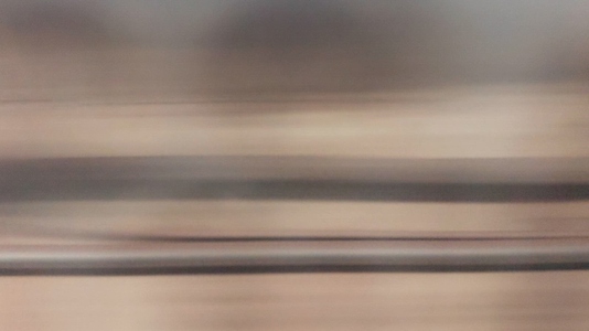 A blurred view of train tracks and landscape speed trace