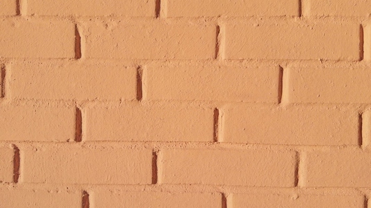 A close up view of a textured orange brick wall background