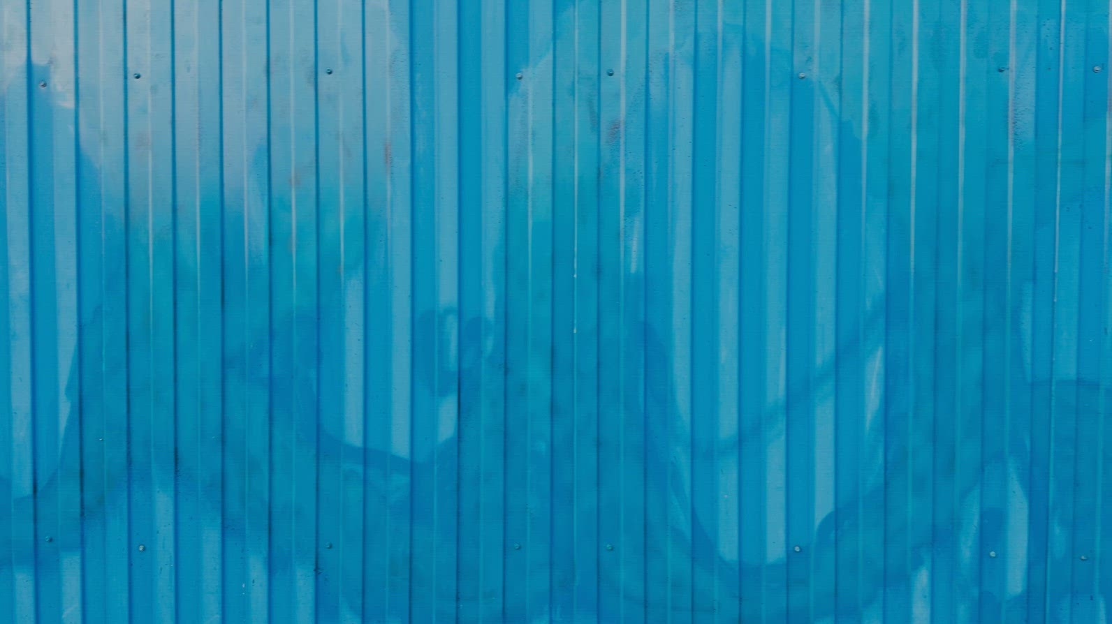 A textured blue metal wall background with vertical lines