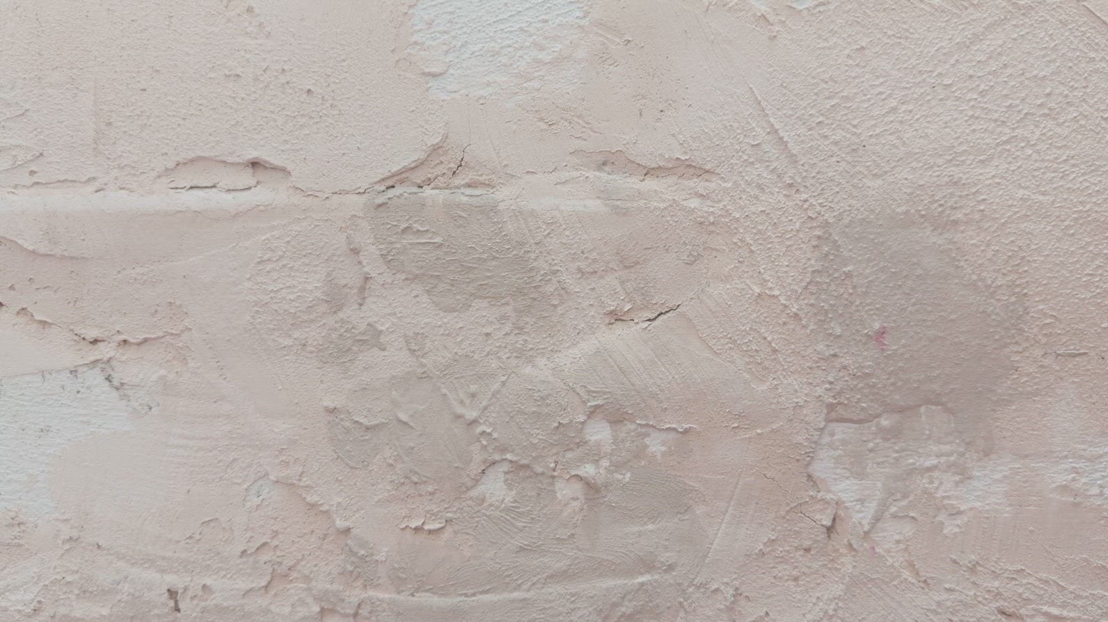 A textured wall background with a light pink plaster finish