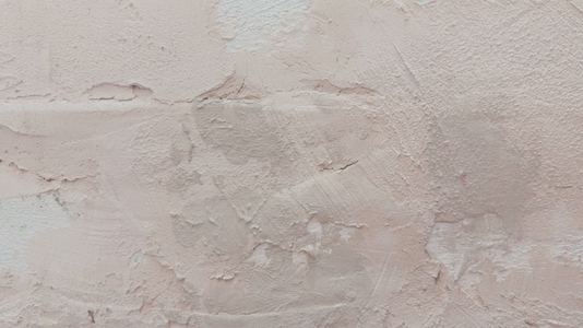 A textured wall background with a light pink plaster finish