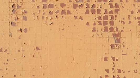 A textured wall background with peeling paint in shades of beige