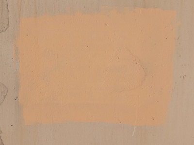 A patch of peach colored rectangle square paint on a concrete