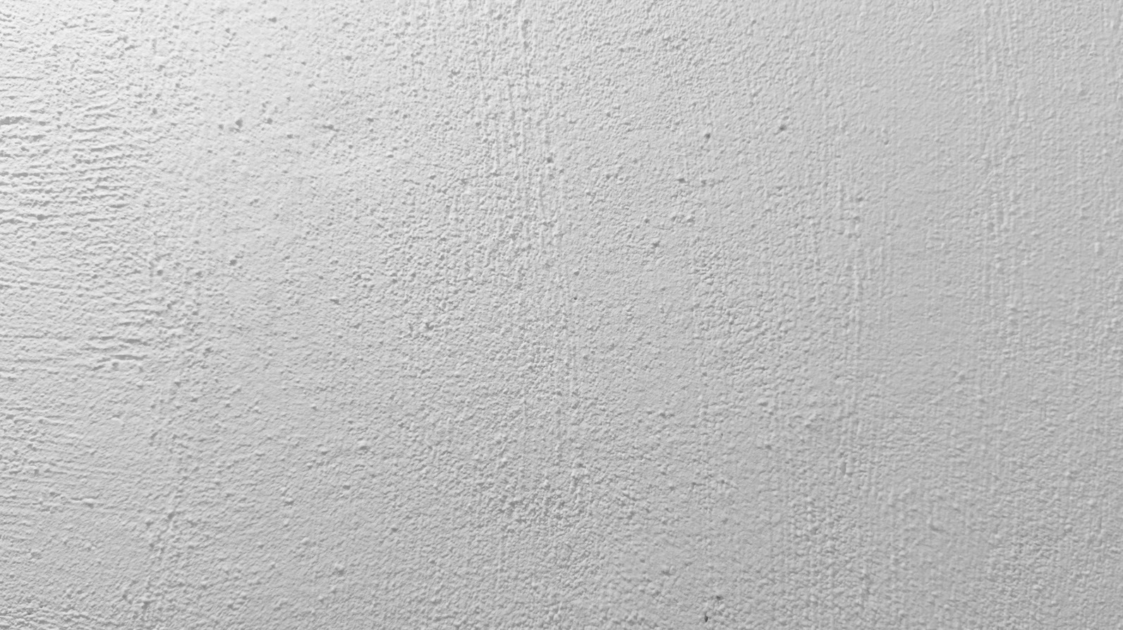 A textured white wall background surface with a rough finish