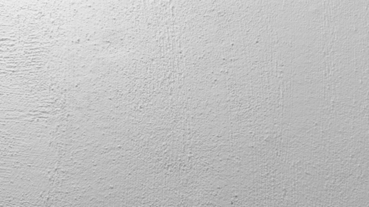 A textured white wall background surface with a rough finish A textured white wall background surface with a rough finish