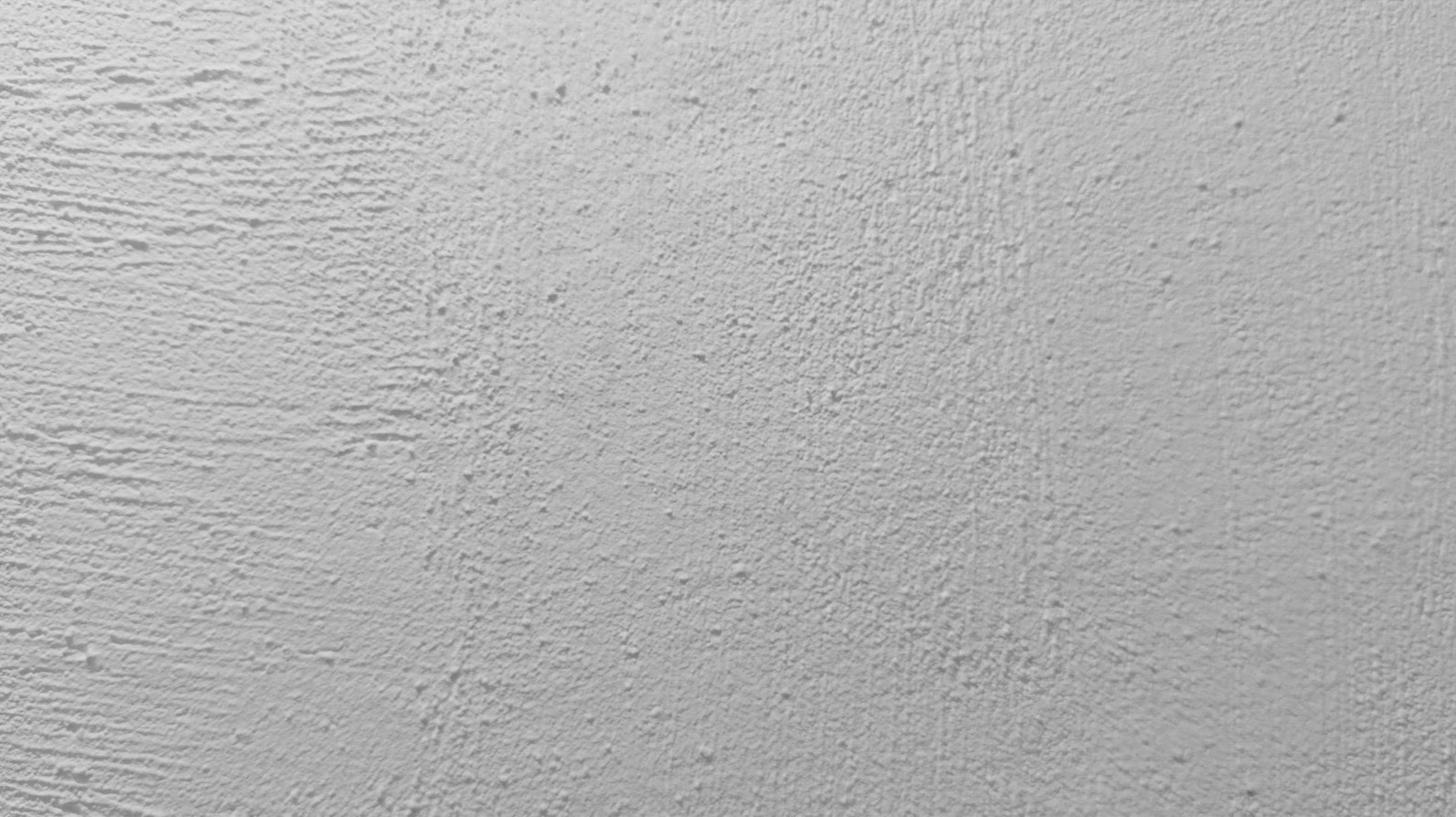 A textured white wall background surface with subtle variations
