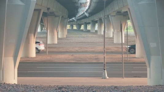 A view under a highway overpass showcasing concrete pillars